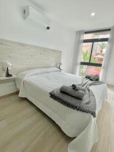 biała sypialnia z łóżkiem i oknem w obiekcie ISLAND SUITES w Aronie