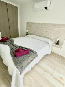 ein Schlafzimmer mit einem weißen Bett mit zwei Handtüchern darauf in der Unterkunft ISLAND SUITES in Arona
