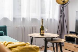 una botella de vino en una mesa con una copa en Uroczy apartament 2 pokoje - 10 min do morza!, en Gdansk