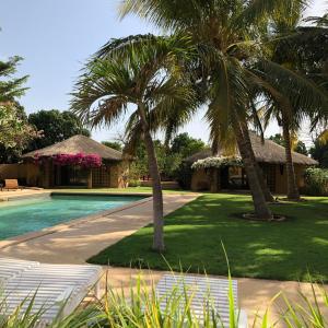 un complexe avec des palmiers et une piscine dans l'établissement Toubana Lodge, à Ngaparou