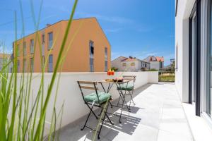 a patio with a table and chairs on a balcony at Bonaca apartments with terrace and private parking in Kaštela