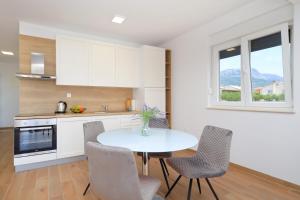 uma cozinha com mesa e cadeiras num quarto em Bonaca apartments with terrace and private parking em Kaštela
