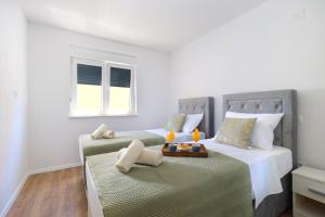 um quarto com duas camas e uma bandeja de comida em Bonaca apartments with terrace and private parking em Kaštela