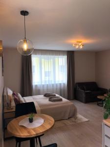 a bedroom with a bed and a table and a couch at Modern studio apartment near the beach - 5 min walk in Liepāja