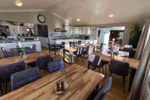 a dining room with wooden tables and chairs at Aurora Lodge Hotel in Hvolsvöllur