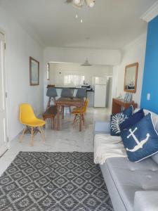 uma sala de estar com um sofá e uma sala de jantar em Apartamento Guarujá Enseada no Guarujá