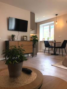 a living room with a flat screen tv on the wall at Modern studio apartment near the beach - 5 min walk in Liepāja