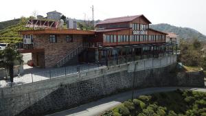 een huis bovenop een stenen muur bij Sarı Köşk Hotel in Rize