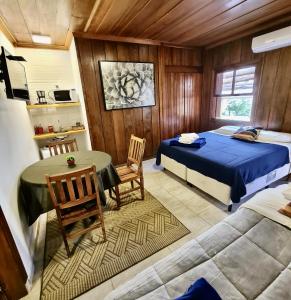 a bedroom with a bed and a table and chairs at Empório reserva da serra com área lazer natureza e excelente localização in Campos do Jordão