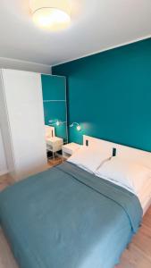 a bedroom with a large bed with a blue wall at Apartament Korfu Jastrzębia Góra in Jastrzębia Góra