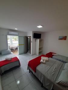 a hotel room with two beds and a television at Pousada APART PenhaFlat- Studio a 700 mts do parque in Penha