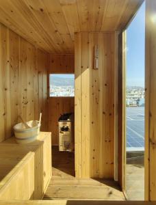 a room with wooden walls and a kitchen with a stove at Unique solar penthouse with jacuzzi and sauna in central Athens in Athens