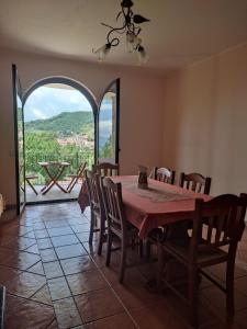 comedor con mesa y sillas y ventana grande en B&B Girasole, en Torraca