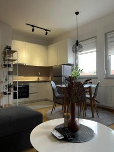 uma sala de estar com uma mesa e uma cozinha em Apartman Lukana lll Banjaluka em Banja Luka