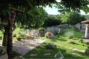 einen Garten mit einem Tisch, Stühlen und einem Baum in der Unterkunft Holiday Home Villa Mavrici in Buzet