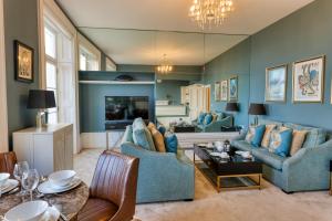 ein Wohnzimmer mit blauen Möbeln und einem Kamin in der Unterkunft The Regency - Sea views and a modern art deco style interior in Ramsgate