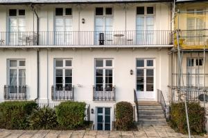 a white building with stairs and balconies at The Regency - Sea views and a modern art deco style interior in Ramsgate