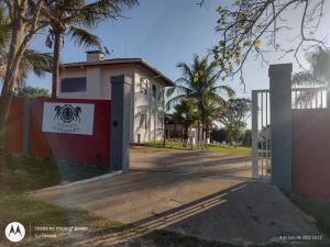 um portão em frente a uma casa com palmeiras em Pousada Ferradura em São Pedro