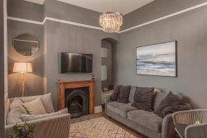 a living room with a couch and a fireplace at Coastal Cottage: Charming three bedroom cottage with private garden in Ramsgate
