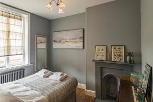 a bedroom with a bed and a fireplace at Coastal Cottage: Charming three bedroom cottage with private garden in Ramsgate