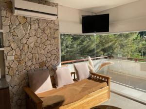 Habitación con sofá y ventana con TV. en Arena de mar depto K en Mar de las Pampas