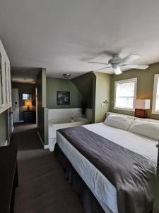 a bedroom with a large bed and a ceiling fan at Inn on the Harbour and Telegraph House in Port Stanley