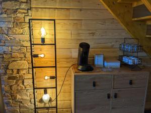 a room with a wooden wall with a lamp on a dresser at Appartemment type chalet in Formiguères