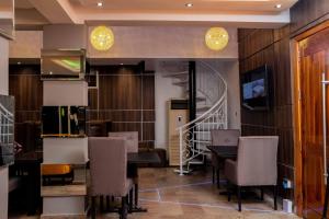 a dining room with a table and chairs and a staircase at Timeless Apartment and Bar in Lagos
