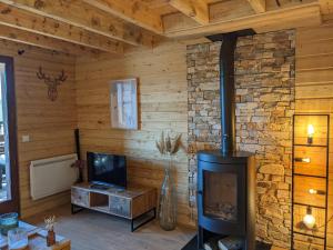 a living room with a fireplace and a tv at Appartemment type chalet in Formiguères