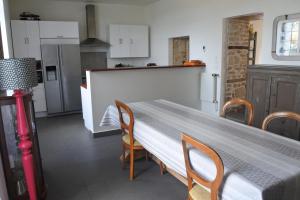 - une cuisine avec une table, des chaises et un comptoir dans l'établissement Maison de village spacieuse et confortable, à Le Gué-de-Velluire