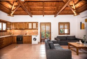 salon z 2 kanapami i kuchnią w obiekcie Casa Gaia w mieście Panormos