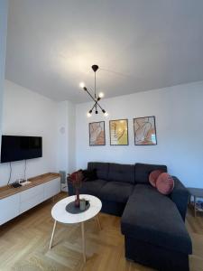 uma sala de estar com um sofá e uma mesa em Apartman Lukana lll Banjaluka em Banja Luka