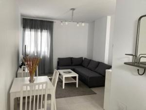 - un salon avec un canapé et une table dans l'établissement APARTAMENTO SAN JUAN, à Sanlúcar de Barrameda