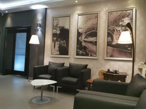 - un salon avec des canapés, une table et des photos sur le mur dans l'établissement Hotel Hercegovina, à Mostar