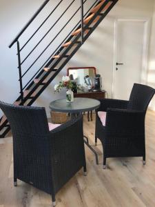 uma mesa e cadeiras num quarto com uma escada em La MER em Bredene