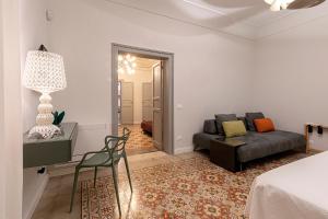 un soggiorno con divano e sedia di Palazzo Guajana a Trapani