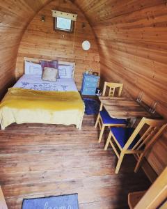 1 dormitorio en una cabaña de madera con cama y escritorio en Skipbridge farm glamping, en York