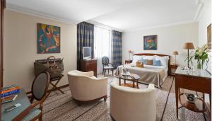 a hotel room with a bed and a living room at Hôtel Juana in Juan-les-Pins