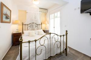 a bedroom with a metal bed with white sheets at Villa Areto in Kamares
