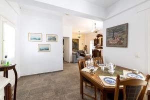 a dining room and living room with a table and chairs at Villa Areto in Kamares