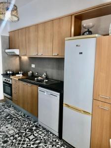a kitchen with a white refrigerator and a sink at City Break by StaySalmar in Torres Vedras