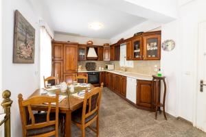 a kitchen with wooden cabinets and a table with chairs at Villa Areto in Kamares