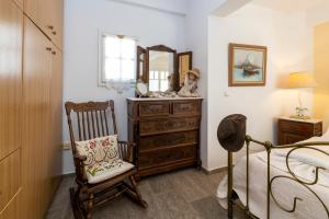 a bedroom with a dresser and a chair and a mirror at Villa Areto in Kamares