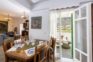 a dining room with a table and chairs and a living room at Villa Areto in Kamares
