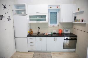 a kitchen with white cabinets and a white refrigerator at Duos Rios in Mostar