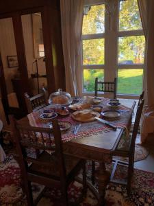 a wooden table with dishes on it in a room with a window at Agroturystyka u Królów in Nowe Guty
