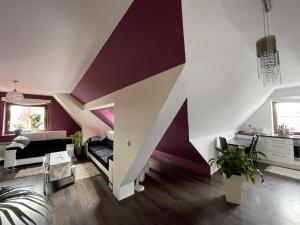 uma sala de estar com uma parede roxa e branca em Apartament Podczerwone em Czarny Dunajec