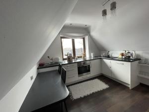 a kitchen with white cabinets and a window at Apartament Podczerwone in Czarny Dunajec