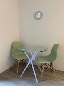 une table en verre et deux chaises vertes dans une pièce dans l'établissement Departamento ideal para viajeros, zona turística, à Santiago