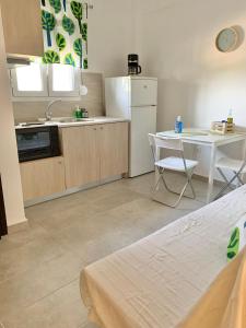 a kitchen with a table and a white refrigerator at Lovely apartment by the sea 2 ….. in Epanomi